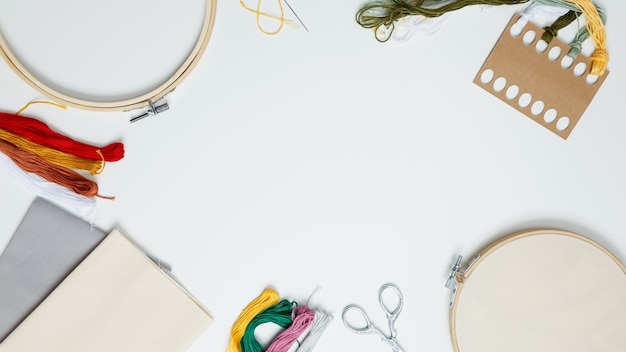 Stoły warsztatowe z tkaninami i przyborami do szycia